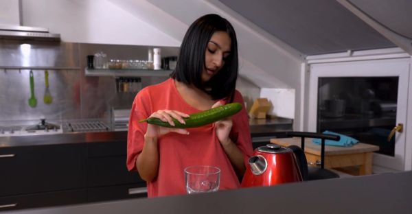 Watch full clip named : A cute girl peels a cucumber for her older man in a sensual scene.